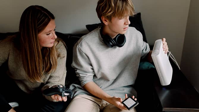 What is WPA? Understanding wi-fi security can help you make sure your own home network is properly protected. Image shows a teenage boy sitting on a sofa and examining a wi-fi router.